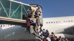 People try to climb onboard a flight at the airport