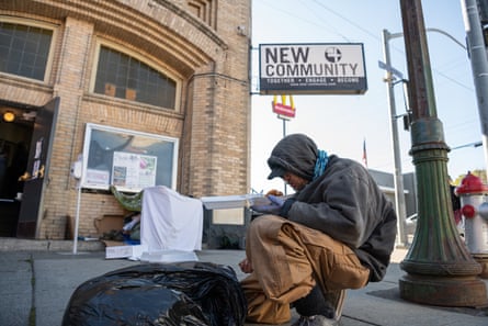 Chris Carver sits outside the New Community church to eat breakfast.
