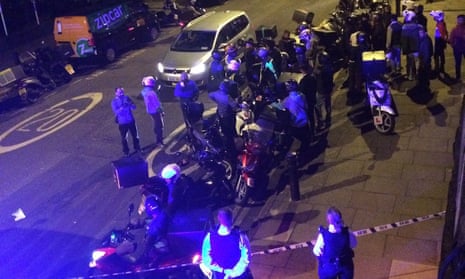 Drivers and police in the street after officers said two men on a moped had carried out a string of acid attacks.