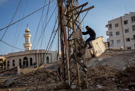 A man fixes electricity cables next to a mosque destroyed in an Israeli strike, after the ceasefire between Israel and Hezbollah, in Tyre, southern Lebanon on Saturday.