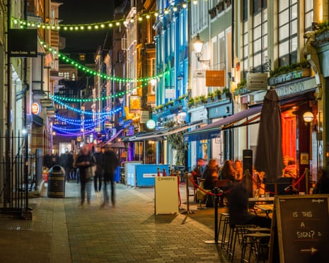 People sitting outside Soho bars at night