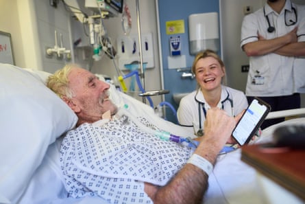 Raymond Dutton, a former police officer, 74, communicates with a nurse using text on a smartphone.