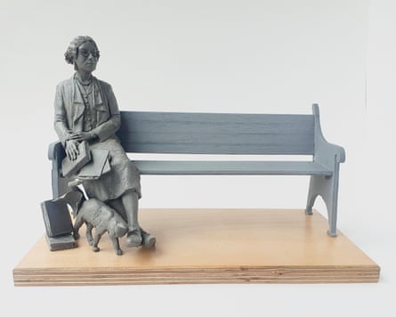 The statue of Sylvia Townsend Warner, who is sitting on a bench holding a book while a cat brushes past her leg.