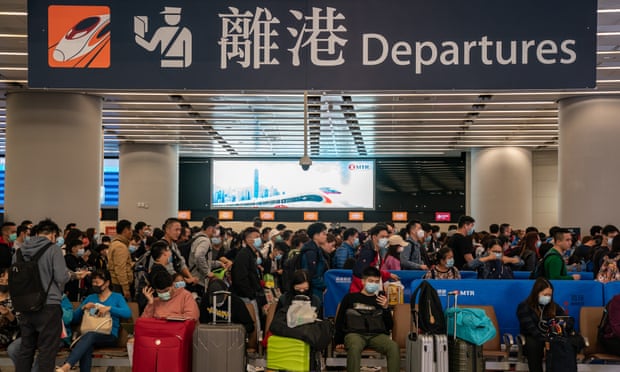 Travellers wearing face masks queue in West Kowloon station, Hong Kong
