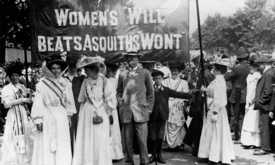 Suffragettes in 1908 hold a banner referring to Herbert Asquith