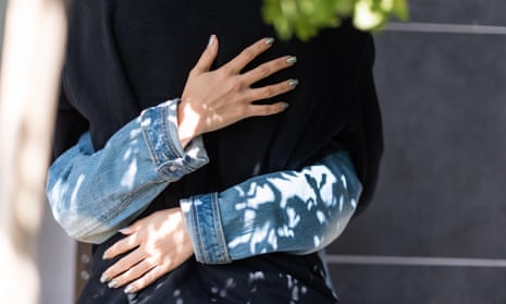 Cropped view of young woman hugging another person outside