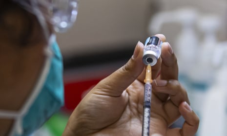 female health worker prepares Pfizer vaccine injection