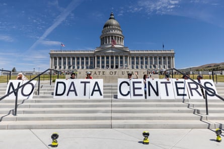Protesters on the steps of the capitol building hold up placards spelling out NO DATA CENTERS