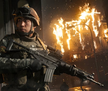 A soldier is seen with a fire raging behind him in the distance.