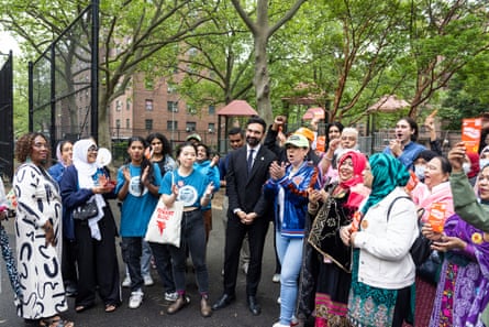 a man in a suit smiles with a group of supporters