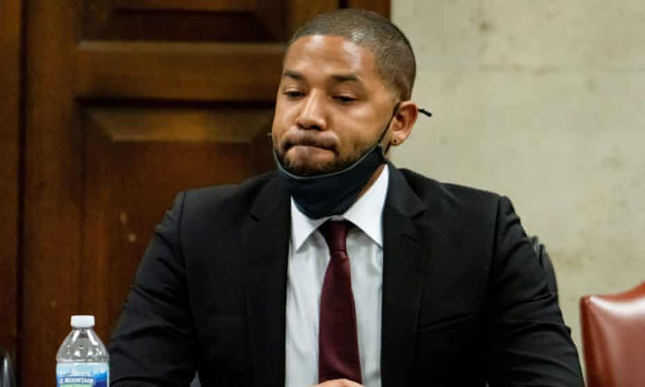 Jussie Smollett sits in court, looking down, a bottle of water in front of him.