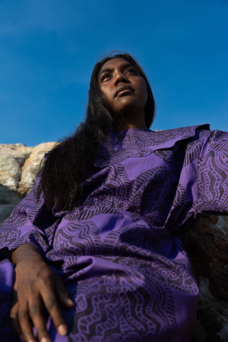 A woman in a purple dress looks up at the sky