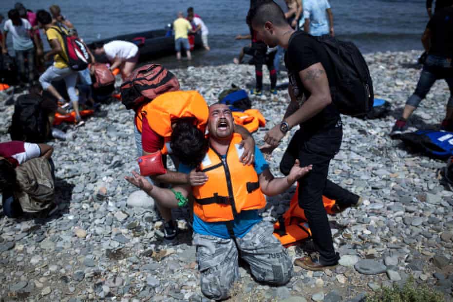 A Syrian prays after arriving on Lesbos in a dinghy from Turkey