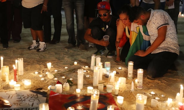 Mourners pay their respects at a memorial for the shooting victims.