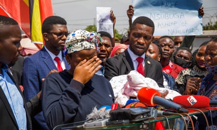 Robert Kyagulanyi with a woman called Halima, whose husband was abducted in December, at press conference in February. Kyagulanyi holds Halima’s one-month old baby.