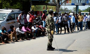 People line up to buy alcohol outside a liquor shop in New Delhi.