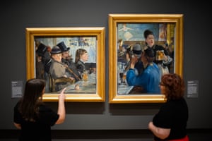 Two people look at Manet’s paintings At the Cafe and Corner of a Cafe-Concert