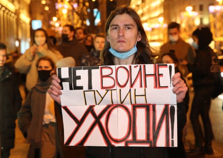 A man holds a placard reading “No war. Putin, go away” during a protest at Pushkinskaya Square.