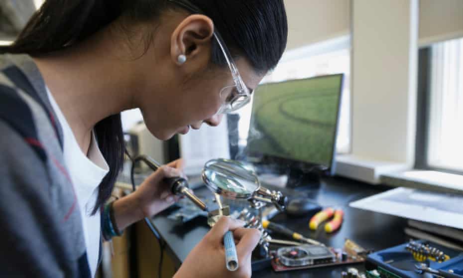 Female engineer assembling electronics