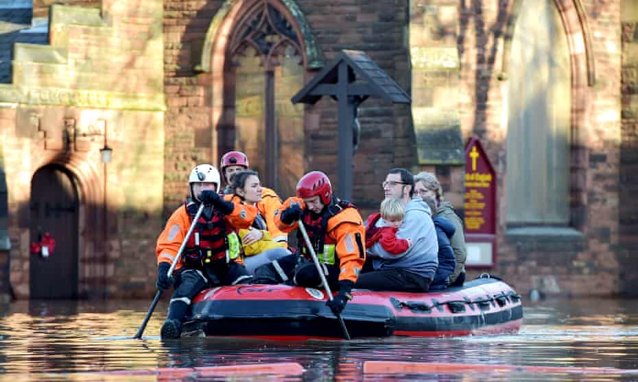 Rescuers paddle a dinghy through Carlisle after Storm Desmond in 2015