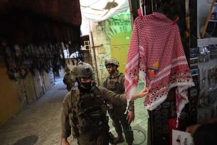Two military personnel patrolling a market