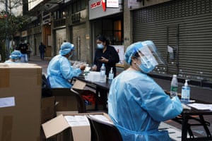 A medical worker in a protective suit helps a resident to register at a makeshift community testing centre at Jordan residential area, in Hong Kong on Friday.