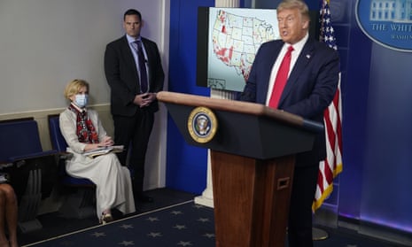 White House coronavirus response coordinator Dr. Deborah Birx, left, listens as President Donald Trump speaks during a news conference in Washington.