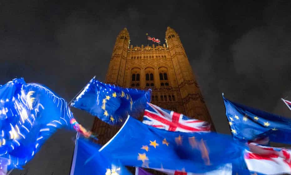 EU and Union flags flutter in the breeze outside of the Houses of Parliament in central London.