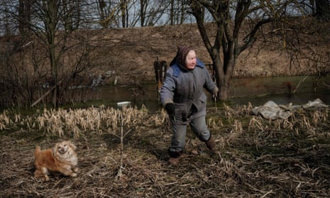 Valentina Ossipova, 77, walks with her dog Dziga in her abandoned garden.