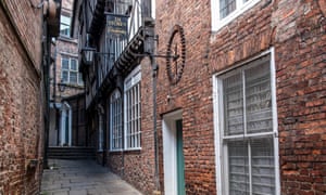 An old sign for a cordwainer (shoemaker) is high up on a wall, down the narrow alley of Lady Peckettâs Yard, York