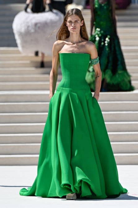 A model at Balenciaga wearing a vivid emerald green strapless gown with a fitted, structured bodice that flares into a full, floor-length skirt.