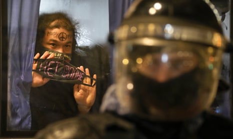 A detained demonstrator shows a sign 'No War!' from a police bus in St Petersburg, Russia, on Thursday.