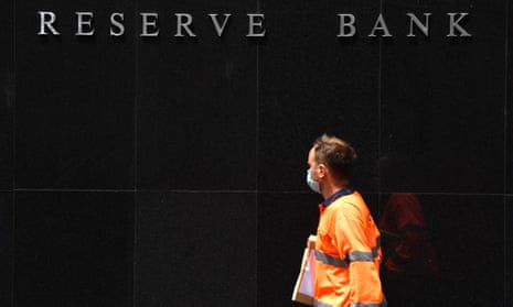 A man in orange high-vis walks past the Reserve Bank of Australia