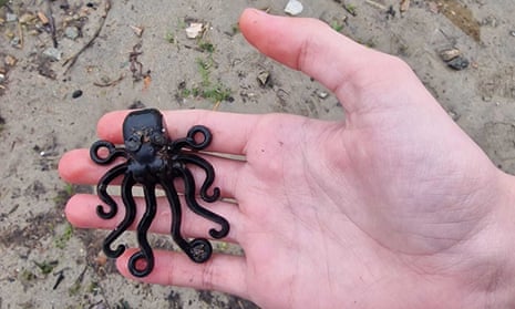 A black octopus figurine sits on the palm of a hand