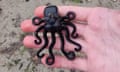 A black octopus figurine sits on the palm of a hand