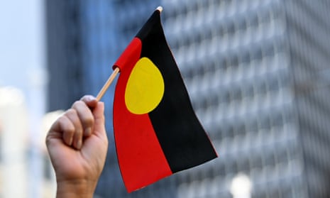 Hand holding a small Aboriginal flag