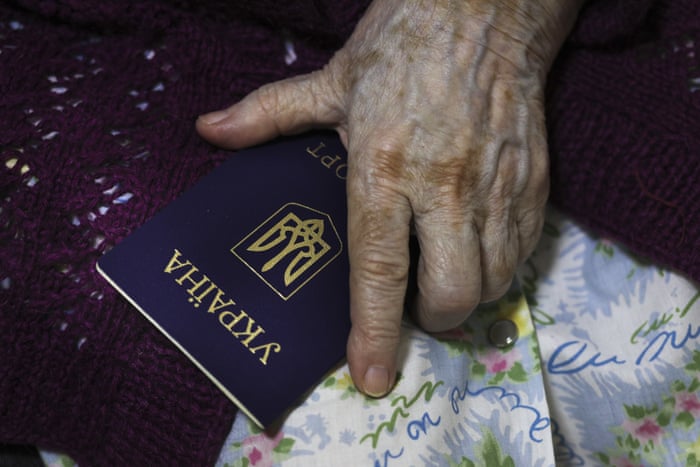 An elderly woman shows her Ukrainian passport as she prepares to vote at a temporary accommodation facility in Volgograd, Russia.