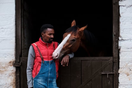 Joe Karari looks at a horse at his stables.