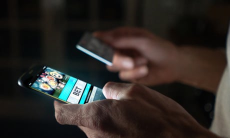 Man betting online at home on his cell phone