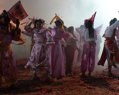 Dancing among firecrackers during a street procession in Trang