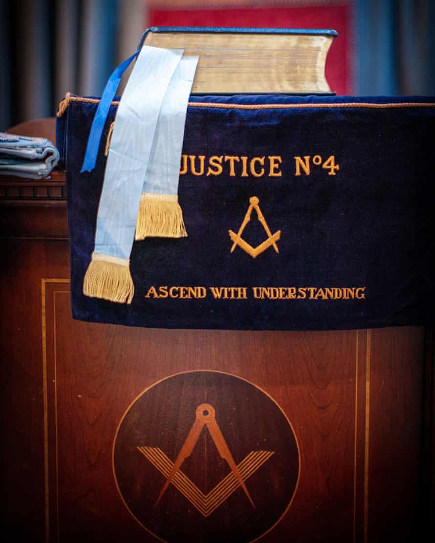 Une Bible placée devant le fauteuil du Maître de la loge.  Le symbole répété de l'équerre et du compas est le plus reconnaissable de la franc-maçonnerie.