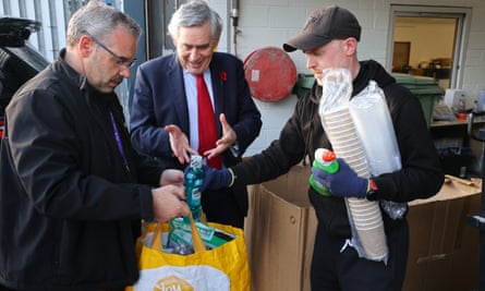 Gordon Brown helps with supplies collected by housing officer Gary Lynch for a tenant.