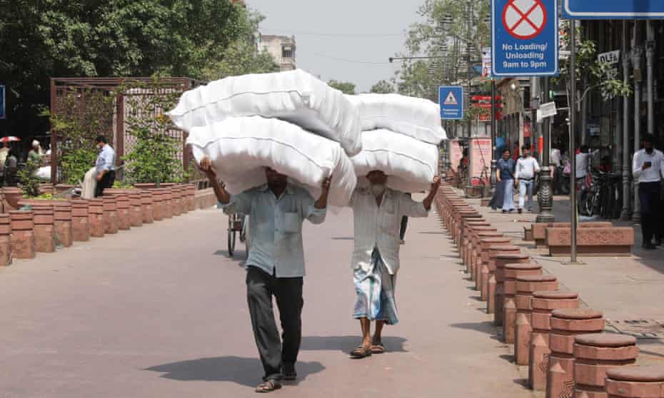 Indian labourers carry goods in Delhi’s scorching heat in May. 