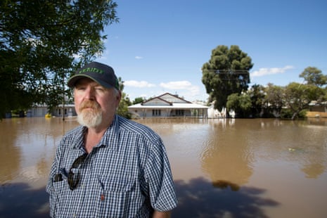 John Shaw in front of his flooded house.