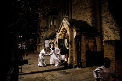 Worshippers leave after a nighttime Christmas Eve service at the Celestial Church of Christ in Elephant and Castle