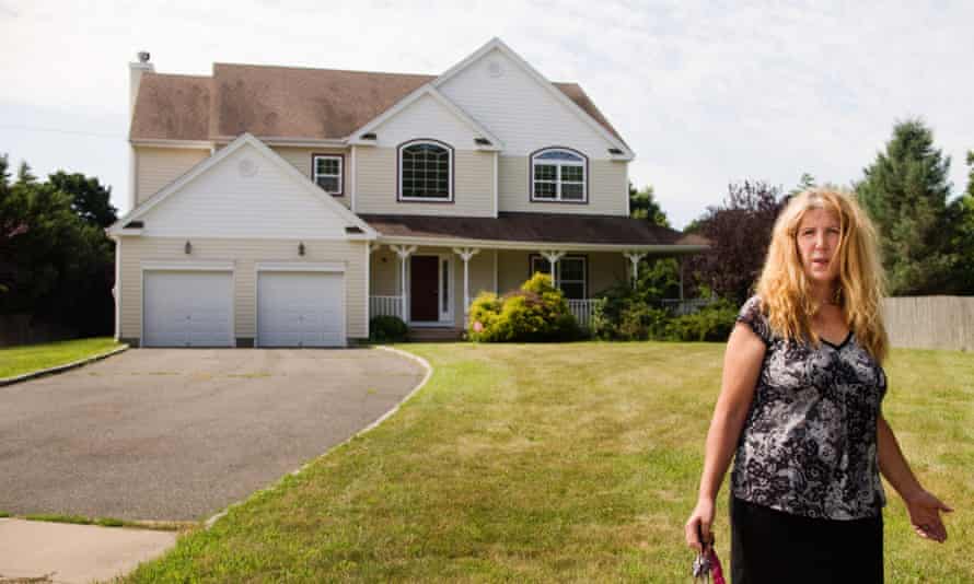 Margaret Besen stands in front of the former Besen family home, now unoccupied in Commack, Long Island.