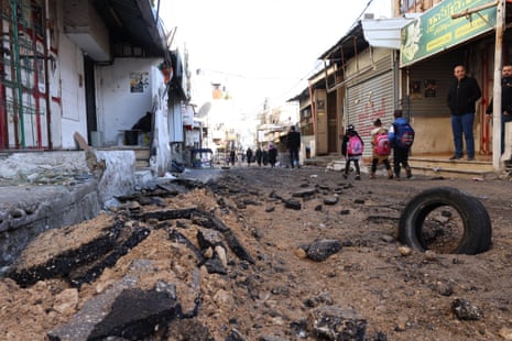 Palestinian school children move along a damaged street after an Isareli army operation at Balta refugee camp, near Nablus in the occupied West Bank.