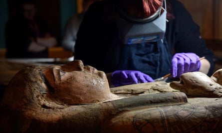 A conservator cleans the sarcophagus of Ta-Kr-Hb who lived 2,700 years ago.