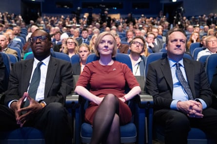 Truss seated between her then chancellor, Kwasi Kwarteng, and her husband, Hugh O’Leary
