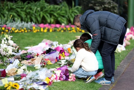 Members of the public leave messages and floral tributes at the gates of Government House in Melbourne